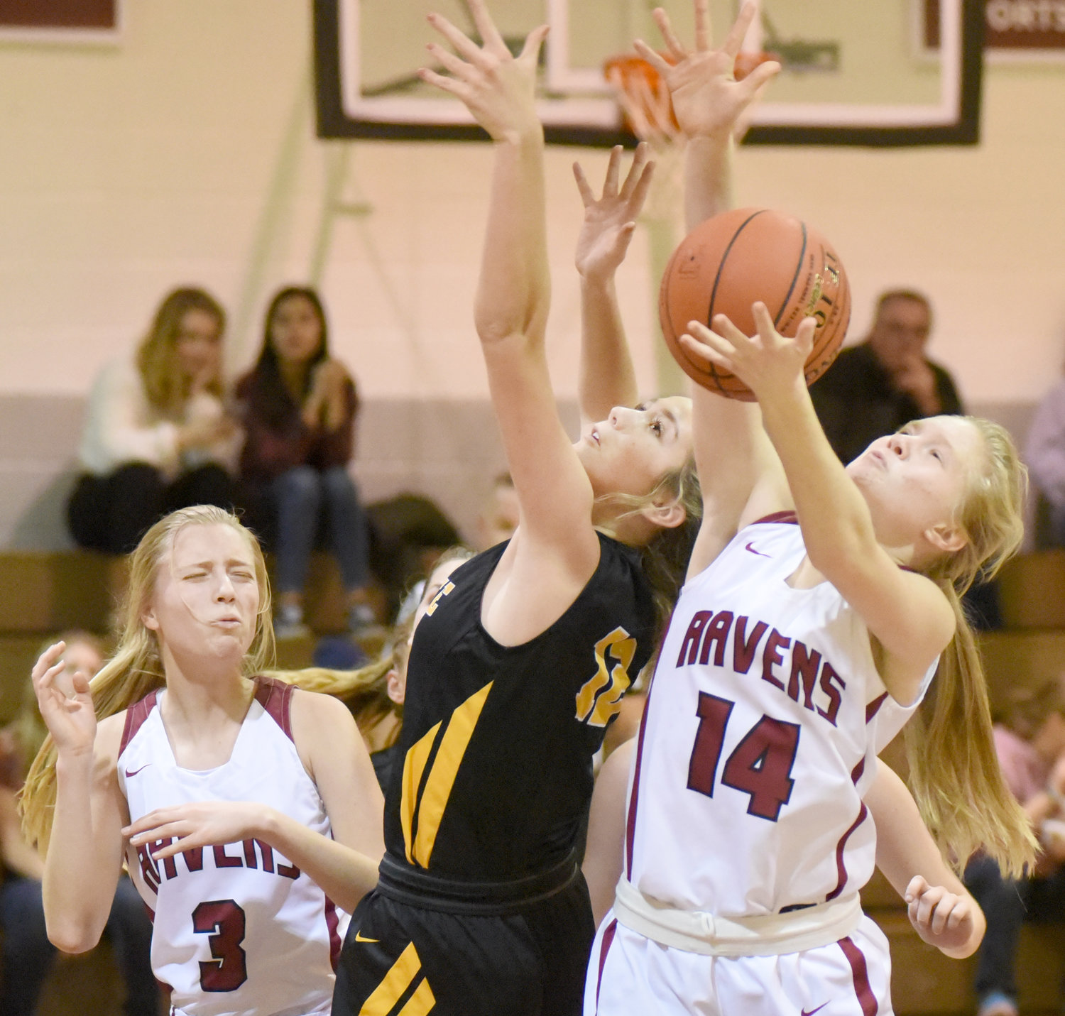 Hillcrest’s Leah Bontrager pulls a rebound away from Lone Tree’s Josie Mullinnex while Sarena Gerber (3) looks on.
